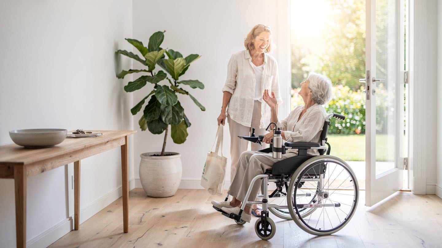 Eine Pflegekraft besucht eine ältere Person zu Hause.